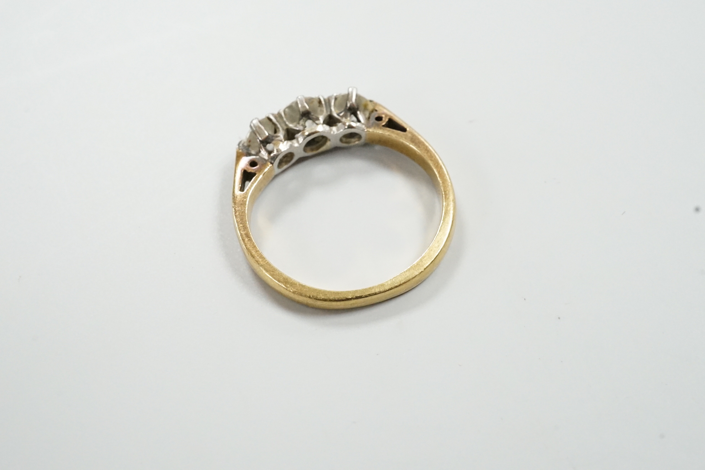A modern 18ct gold and three stone diamond set ring, size K/L, gross weight 3.6 grams.